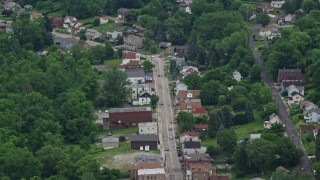 AX105_092E - 4.8K aerial stock footage of homes and shops on a small town road, Penn Hills, Pennsylvania