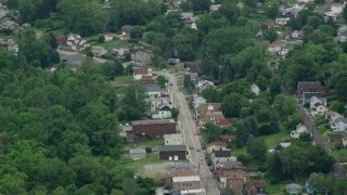AX105_093 - 4.8K aerial stock footage of shops and homes on small town road, Penn Hills, Pennsylvania