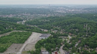 AX105_098E - 4.8K aerial stock footage flying over suburban neighborhood, tilt to reveal Pittsburgh, Penn Hills, Pennsylvania