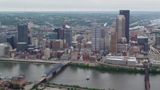 AX105_114 - 4.8K aerial stock footage orbiting skyscrapers across the river, Downtown Pittsburgh, Pennsylvania