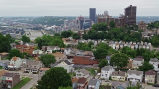 AX105_118E - 4.8K aerial stock footage of hillside homes revealing downtown skyscrapers, Downtown Pittsburgh, Pennsylvania
