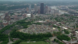 AX105_179 - 4.8K aerial stock footage flying over suburbs toward Downtown Pittsburgh, Pennsylvania