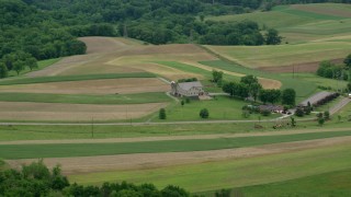 AX106_045 - 4.8K aerial stock footage of a farmhouse and farmland in Beaver Falls, Pennsylvania
