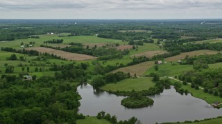 AX106_061E - 4.8K aerial stock footage flying over pond and farmland in Enon Valley, Pennsylvania