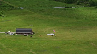 AX106_134 - 4.8K aerial stock footage of skydivers on the Ground in Leavittsburg, Ohio