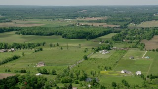 AX106_142 - 4.8K aerial stock footage of farmland and country road in Windham, Ohio