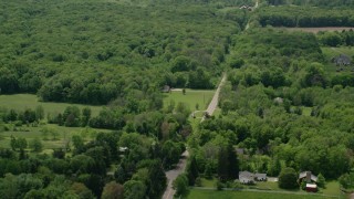 AX106_145 - 4.8K aerial stock footage of a country road and forest in Garrettsville, Ohio