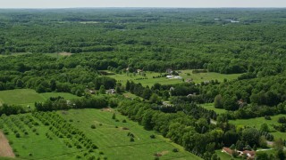 AX106_150E - 4.8K aerial stock footage flying over rural homes and forest in Hiram, Ohio