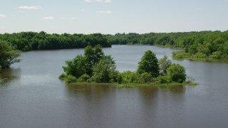 AX106_158 - 4.8K aerial stock footage flying by a tiny island with trees in Akron City Reservoir, Chagrin Falls, Ohio