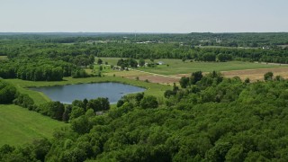 AX106_163E - 4.8K aerial stock footage of a pond by Farm in Chagrin Falls, Ohio