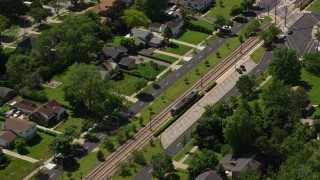 AX106_191 - 4.8K aerial stock footage of a commuter train and suburban homes in Cleveland, Ohio