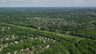 AX107_064 - 4.8K aerial stock footage of a suburban neighborhood among trees, Solon, Ohio