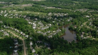 AX107_072 - 4.8K stock footage aerial video flying over trees and lakeside homes, Aurora, Ohio