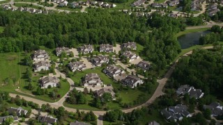 AX107_072E - 4.8K aerial stock footage flying over trees and lakeside homes, Aurora, Ohio
