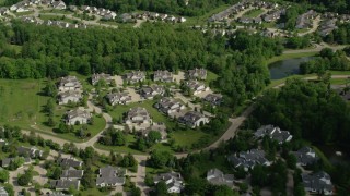 AX107_073 - 4.8K aerial stock footage flying over trees and lakeside homes, Aurora, Ohio