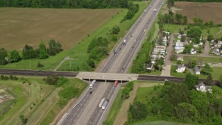 AX107_084E - 4.8K aerial stock footage of an interstate cutting through farmland, Ravenna, Ohio
