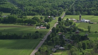 AX107_089E - 4.8K aerial stock footage of barns and farmland along a country road, Ravenna, Ohio