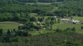 AX107_090 - 4.8K aerial stock footage of barns and farmland along a country road, Ravenna, Ohio