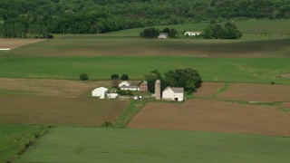 AX107_096 - 4.8K aerial stock footage of a farmhouse and barns, Newton Falls, Ohio