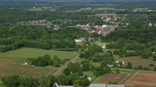 AX107_098E - 4.8K aerial stock footage of farmland and small town, Columbiana, Ohio