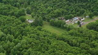 AX107_120E - 4.8K aerial stock footage flying away from forests, reveal rural homes, Darlington, Pennsylvania