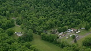 AX107_121 - 4.8K aerial stock footage flying away from forests and rural homes, Darlington, Pennsylvania