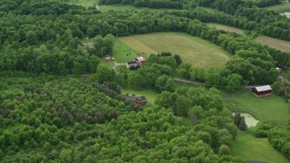 AX107_122E - 4.8K aerial stock footage flying away from forests to reveal rural homes, Darlington, Pennsylvania
