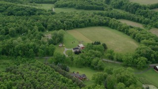 AX107_123 - 4.8K aerial stock footage flying away from rural homes and forests, Darlington, Pennsylvania