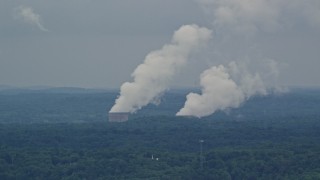 AX107_124E - 4.8K aerial stock footage of steam rising from a power station's cooling towers, Beaver Valley Power Station, Pennsylvania