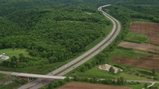 AX107_128E - 4.8K aerial stock footage of an interstate bordered by forests and farmland, Beaver Falls, Pennsylvania