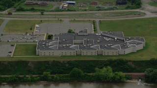 AX107_143 - 4.8K aerial stock footage flying by Beaver County Jail along the water, Aliquippa