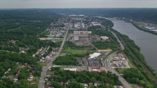 AX107_144E - 4.8K aerial stock footage approaching small factories along a river, Ambridge, Pennsylvania
