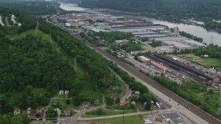 AX107_151E - 4.8K aerial stock footage tilting up from homes to reveal warehouses along Ohio River, Leetsdale, Pennsylvania