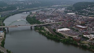 AX107_177E - 4.8K aerial stock footage of Birmingham Bridge, Monongahela River, and an urban Pittsburgh neighborhood, Pennsylvania