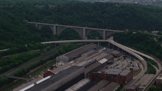 AX108_010 - 4K aerial stock footage of George Westinghouse Bridge surrounded by trees, Pittsburgh, Pennsylvania