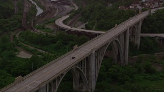 AX108_012E - 4K aerial stock footage of George Westinghouse Bridge among trees, Pittsburgh, Pennsylvania