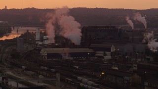 AX108_019 - 4K aerial stock footage of U.S. Steel Mon Valley Works and smoke stacks, Braddock, Pennsylvania, sunset