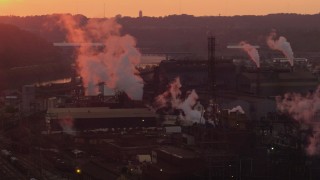 AX108_020 - 4K aerial stock footage of the U.S. Steel Mon Valley Works and smoke stacks, Braddock, Pennsylvania, sunset