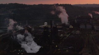 AX108_025 - 4K aerial stock footage passing by buildings at the U.S. Steel Mon Valley Works, Braddock, Pennsylvania, sunset