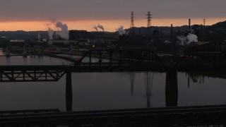 AX108_031 - 4K aerial stock footage of U.S. Steel Mon Valley Works viewed from a bridge, Braddock, Pennsylvania, sunset