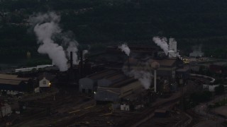 AX108_039 - 4K aerial stock footage passing a building at the U.S. Steel Mon Valley Works, Braddock, Pennsylvania, twilight