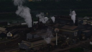 AX108_040 - 4K aerial stock footage passing a building at the U.S. Steel Mon Valley Works, Braddock, Pennsylvania, twilight