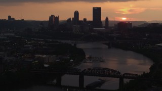 AX108_052 - 4K aerial stock footage of Downtown Pittsburgh skyline seen from the Monongahela River, Pennsylvania, sunset