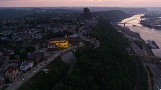 AX108_102E - 4K aerial stock footage flyby Highmark Stadium, St. Mary of the Mount, suburban homes in Pittsburgh, Pennsylvania, twilight