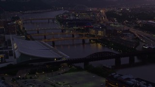 AX108_134E - 4K aerial stock footage of bridges spanning the Allegheny River near PNC Park, Downtown Pittsburgh, twilight