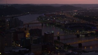 AX108_141E - 4K aerial stock footage of PNC Park, Heinz Field and bridges spanning Allegheny River, Pittsburgh, Pennsylvania, twilight