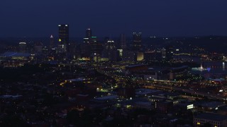 AX108_156 - 4K aerial stock footage approaching Heinz Field and skyscrapers, Downtown Pittsburgh, Pennsylvania, night