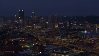 AX108_157E - 4K aerial stock footage approaching Downtown Pittsburgh and Heinz Field, Pennsylvania, night