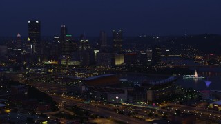 AX108_158 - 4K stock footage aerial video approaching Downtown Pittsburgh while flying by Heinz Field, night