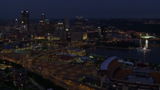 AX108_160E - 4K aerial stock footage flying toward Downtown Pittsburgh passing Heinz Field, Pennsylvania, night